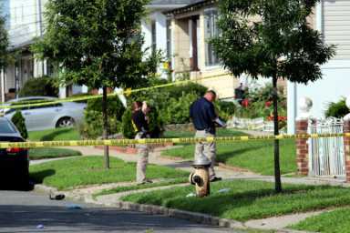 Police inspect the front of a home on Williamson Avenue in Queens where a suspected burglar was fatally attacked by two brothers after breaking into the dwelling on July 30.