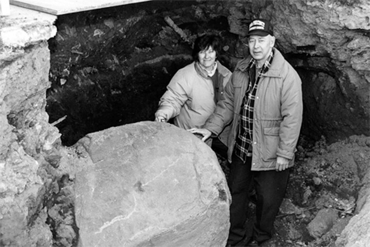 Greater Ridgewood Historical Society historians Linda Monte and George Miller stand next to Arbitration Rock after it was unearthed in 1999.