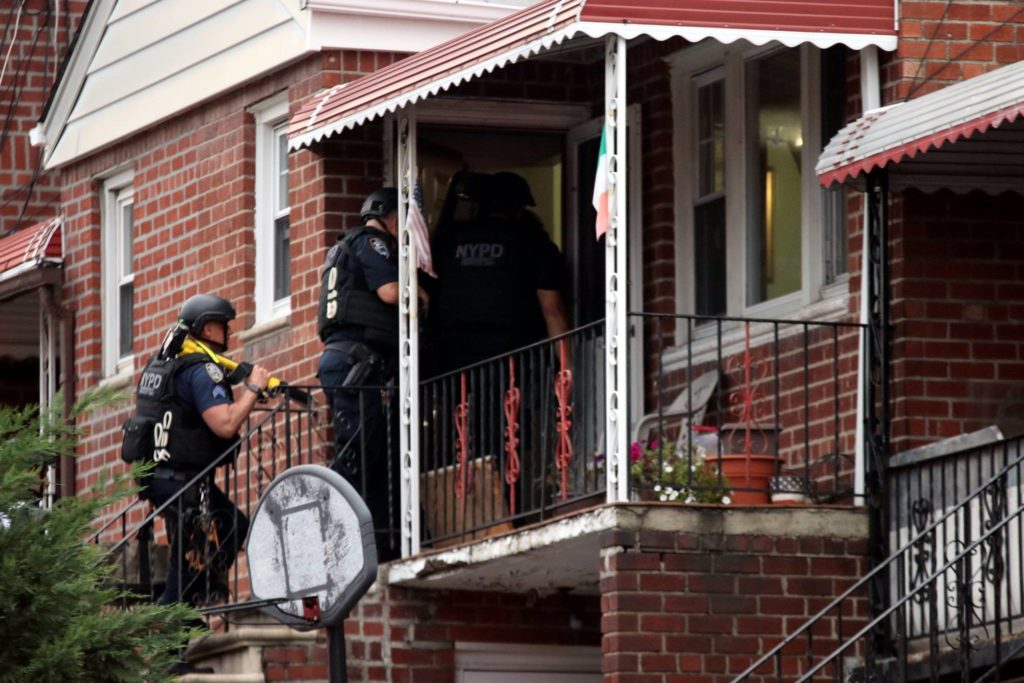 Police enter the 69th Street home in Maspeth following a police-involved shooting on Sept. 17.