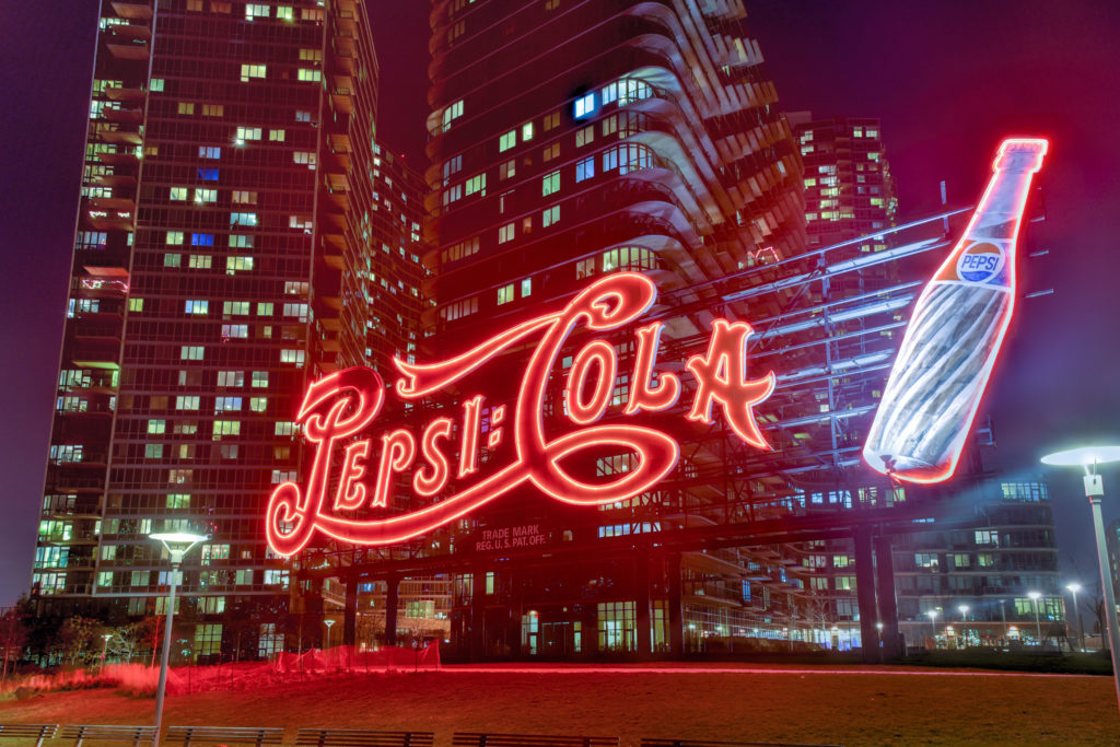 The landmarked Pepsi-Cola sign at Gantry Plaza State Park, in all its glowing glory (photo via Shutterstock)