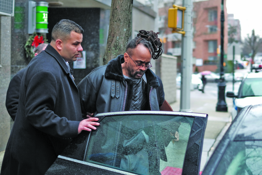 Allasheed Allah is led into a waiting police car outside the 112th Precinct stationhouse on Dec. 13.