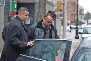 Allasheed Allah is led into a waiting police car outside the 112th Precinct stationhouse on Dec. 13.