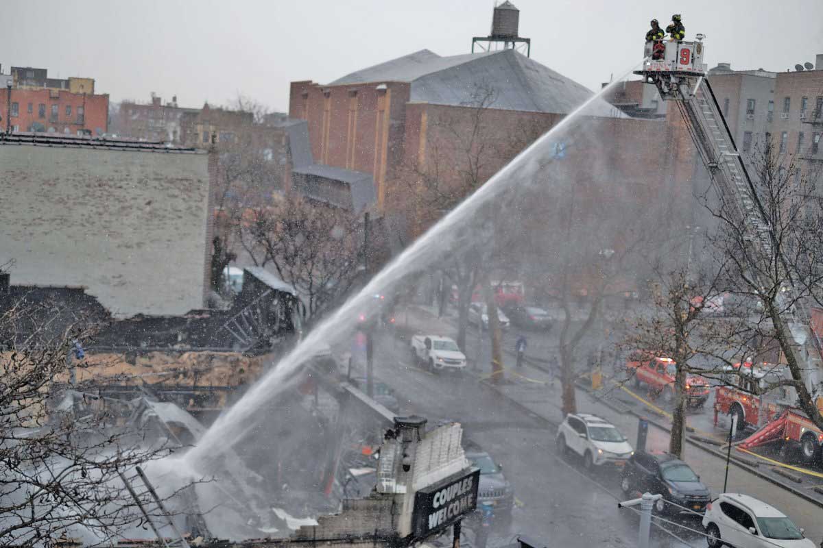 Video shows firefighters caught in a violent blast as five-alarm fire destroys row of Sunnyside shops