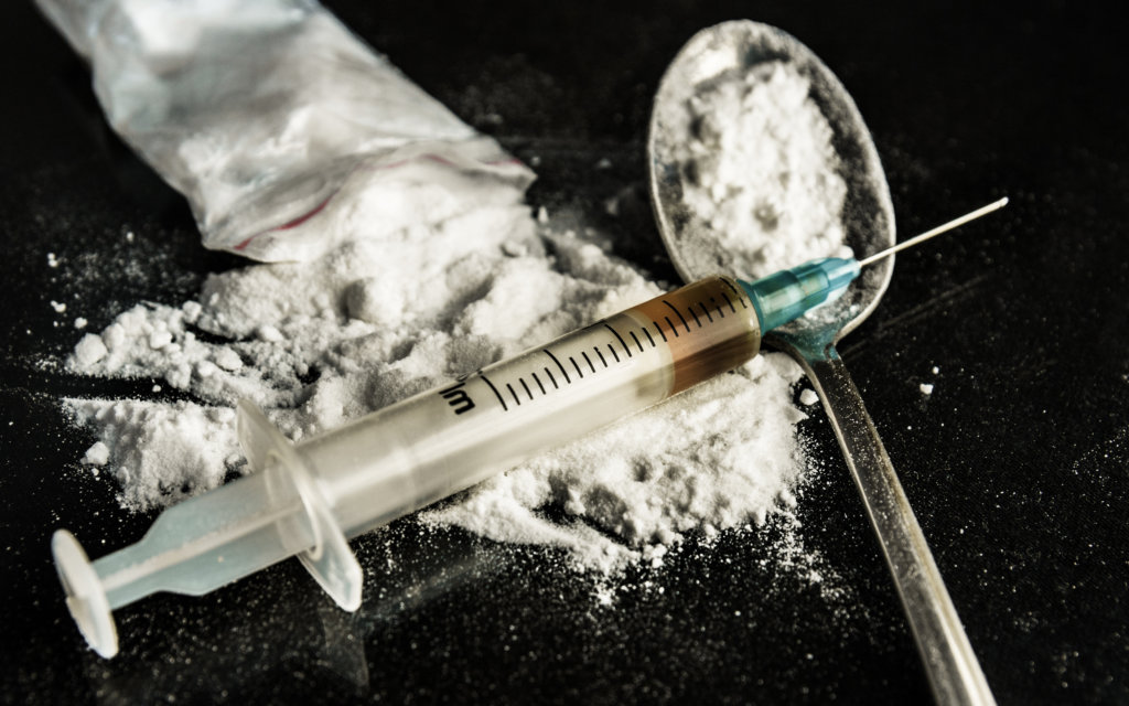 A drug syringe and a spoon with cooked heroin
