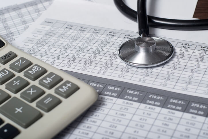 Calculator and stethoscope on financial statement concept for finance health check or cost of healthcare