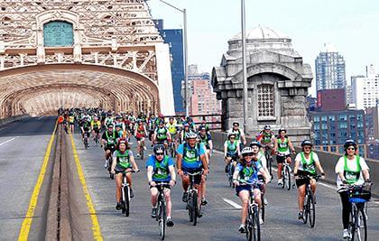 Five Boro Bike Tour riders relax in sunny Astoria Park