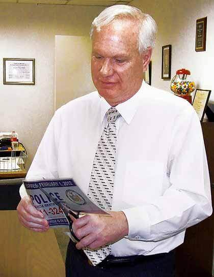 Avella destroys his placard in protest of parking perks