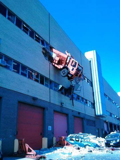 Sanitation truck still three floors up in the air after crash