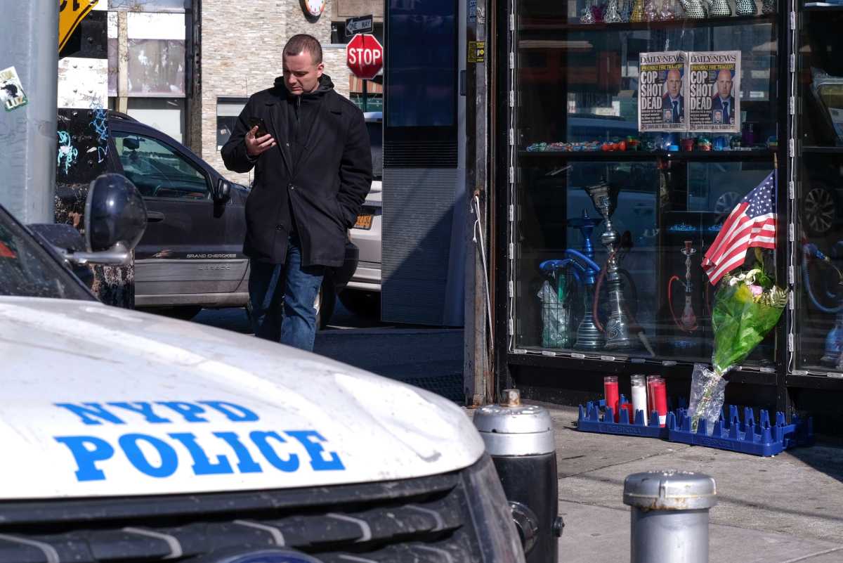 A shrine in front of a bodega steps from the 102nd Precinct memorializes Det. Brian Simonsen, a regular who was struck down by friendly fire.