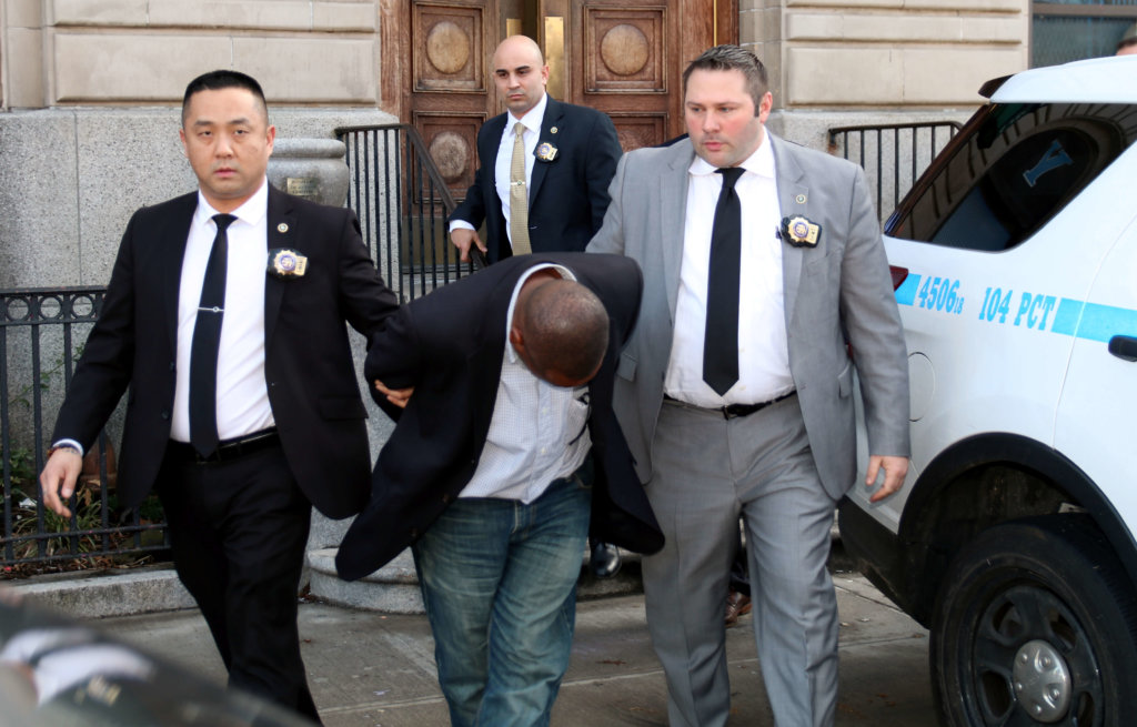 Anthony Hobson put his head down as detectives escorted him out of the 104th Precinct stationhouse in Ridgewood on Feb. 8 after being charged in the Feb. 3 murder of Jennifer Irigoyen.