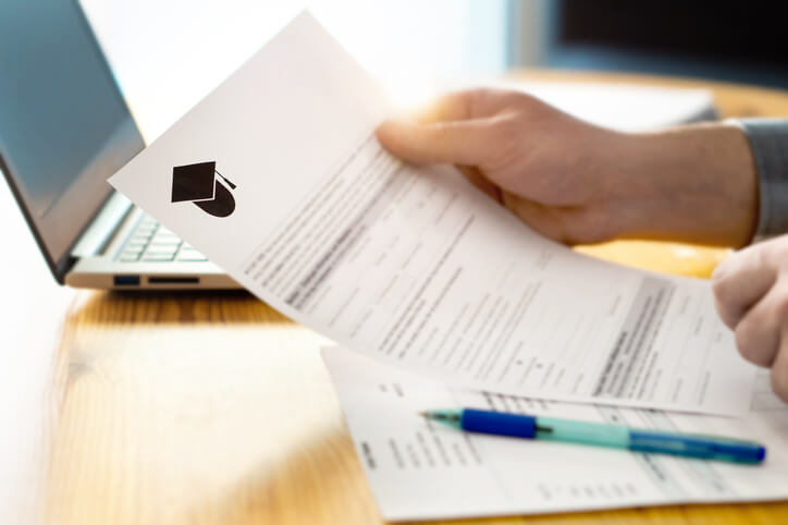 Man reading college or university application or document from school. College acceptance letter or student loan paper.