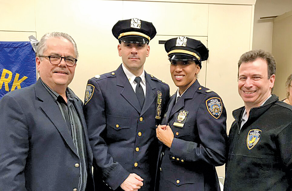 Captain Victoria Perry, the new leader of the 104th Precinct, (second from right) receives her commanding officer's pin from former 104th Precinct boss Deputy Inspector John Mastronardi (second from left) at the April 25 Juniper Park Civic Association meeting. Also pictured are Tony Nunziato (left), Juniper Park Civic Association president, and Len Santoro (right), 104th Precinct Community Council president.