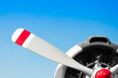 Vintage airplane propeller with radial engine on blue sky
