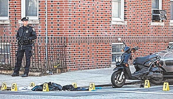 An officer stands guard after a deadly shooting at the corner of 108th Street and 103rd Avenue in Richmond Hill on April 19, 2014.