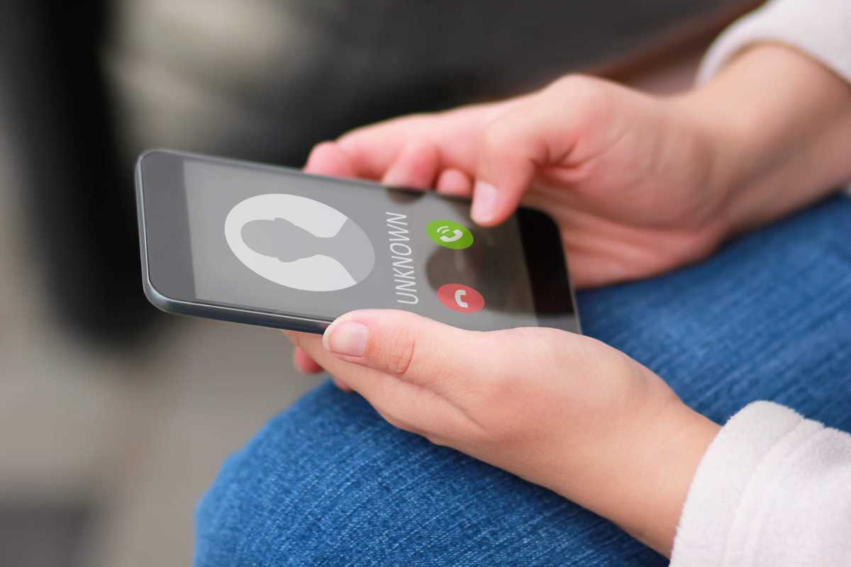 Close up of woman’s hands with smartphone and unknown incoming phone call on it, fraud or scam schemes