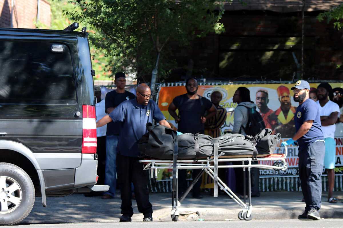 The Medical Examiner's team removes the body of a 67-year-old man who was struck by an elevator lift in South Jamaica on July 15.