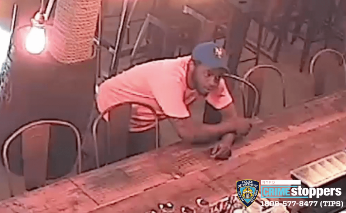 The suspect involved in an assault at a Jackson Heights train station is shown purchasing water at a nearby restaurant following the incident.