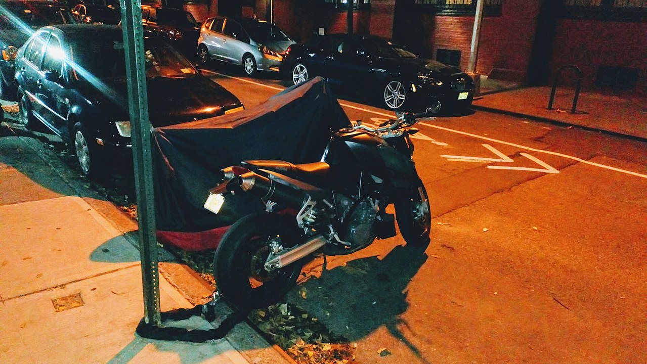 1280px-NYC_-_motorcycle_parked_on_street_at_night