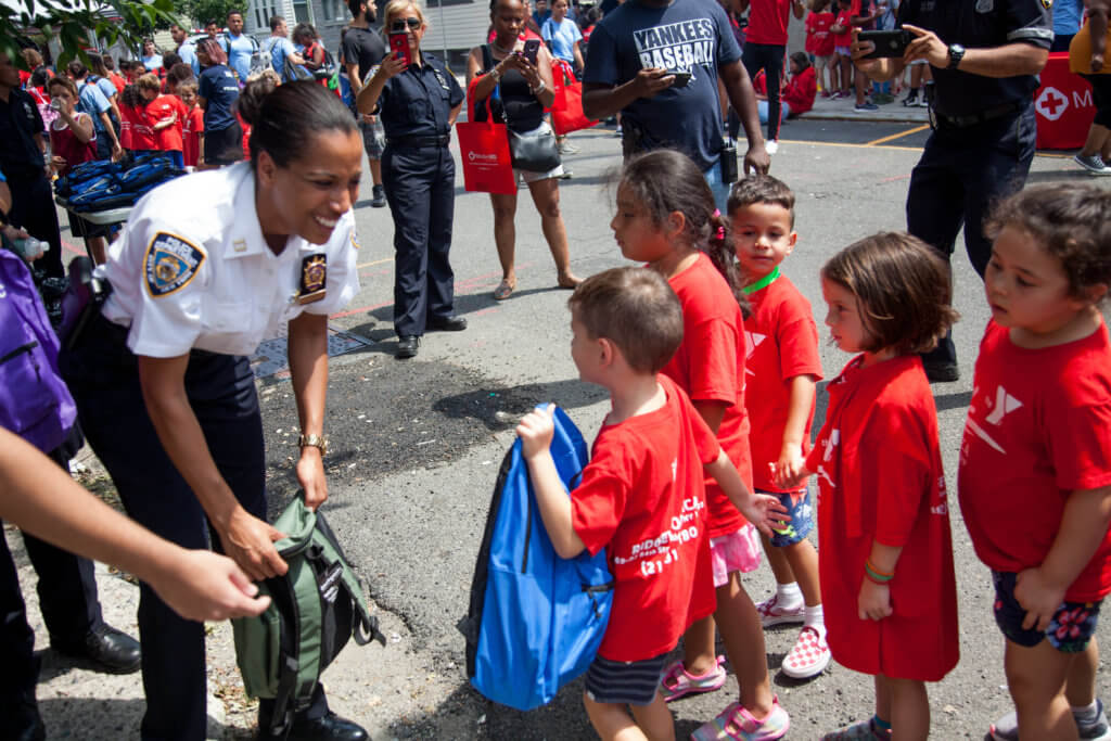 Captain Victoria Perry, commander of the 104th Precinct, greets children during the command's inaugural backpack giveaway in Ridgewood on Aug. 20.