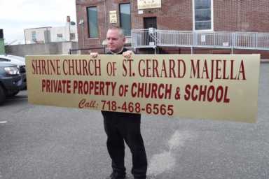 Rev Gannon holding sign