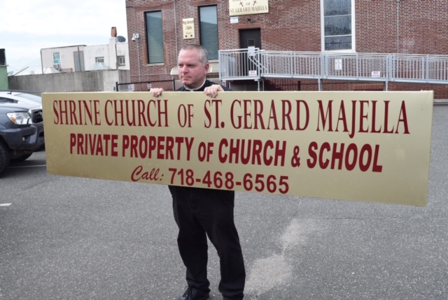 Rev Gannon holding sign