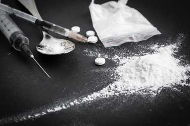 Drug syringe and cooked heroin on spoon