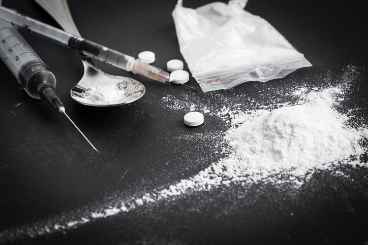 Drug syringe and cooked heroin on spoon