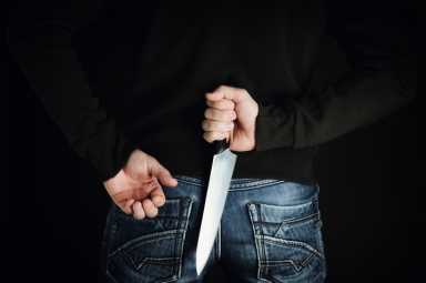 riminal with large sharp knife behind his back