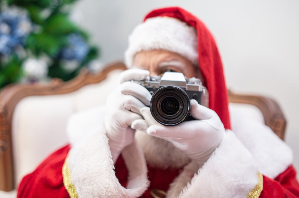 Santa Claus holding vintage camera.