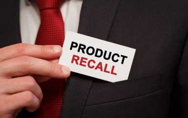 Businessman putting a card with text Product Recall in the pocket
