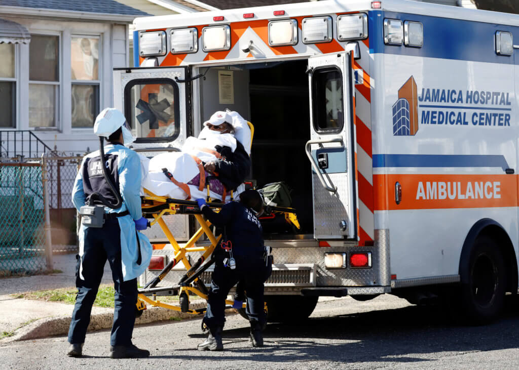 FILE PHOTO: Emergency Medical Technicians (EMT) lift a patient into an ambulance as the the outbreak of coronavirus disease (COVID-19) continues, in New York