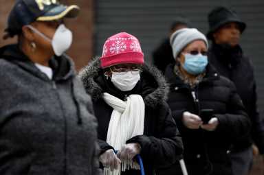 FILE PHOTO: People wait in line for donated food distribution at the Queensbridge houses, a NYCHA public housing complex, during the outbreak of the coronavirus disease (COVID-19) in Queens, New York