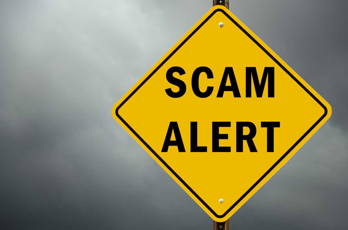 Scam alert conceptual traffic sign and stormy sky