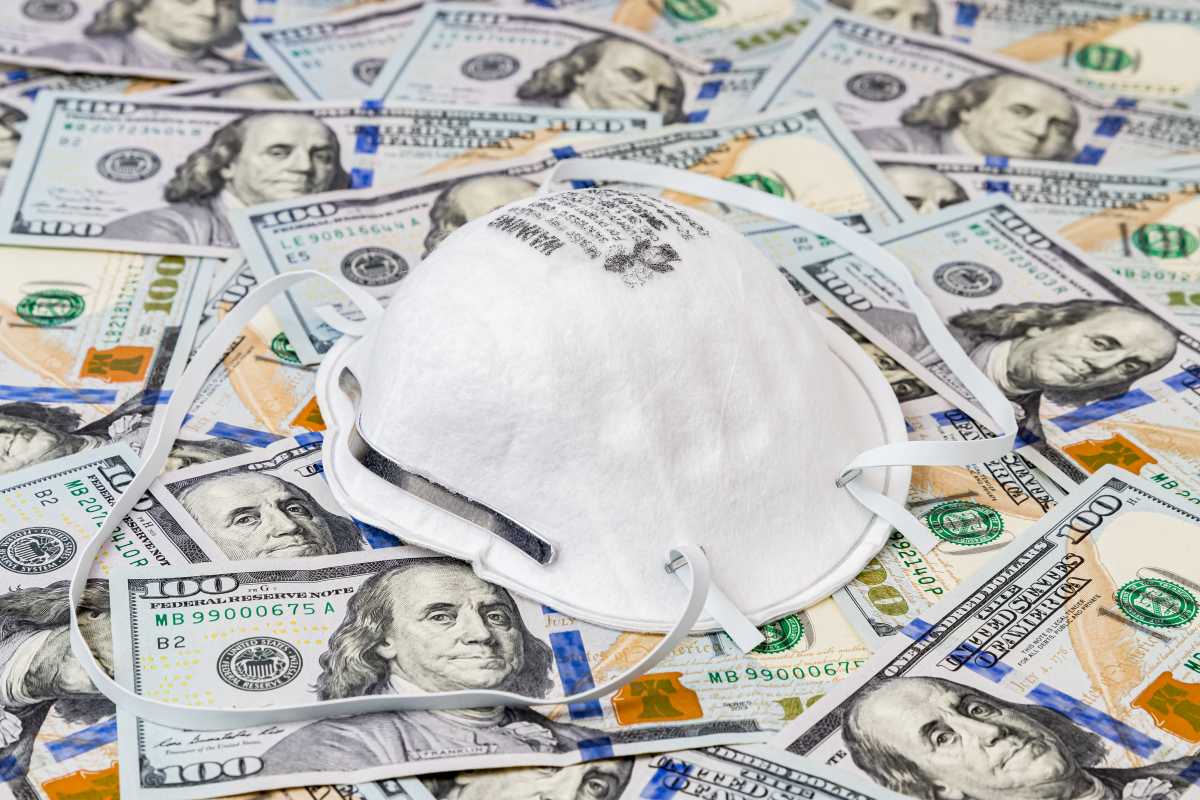 N95 respirator mask with 100 dollar bills. Concept of supply and demand, shortage and price gouging due to Covid-19 coronavirus worldwide pandemic