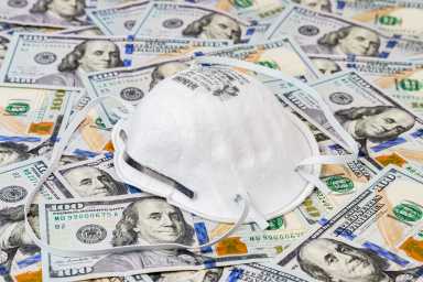 N95 respirator mask with 100 dollar bills. Concept of supply and demand, shortage and price gouging due to Covid-19 coronavirus worldwide pandemic