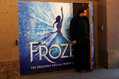 FILE PHOTO: A worker looks out from the closed St James theater after it was announced that Broadway shows will cancel performances due to the coronavirus outbreak in New York