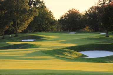 Empty golf course in autumn at sunset with sand bunkers