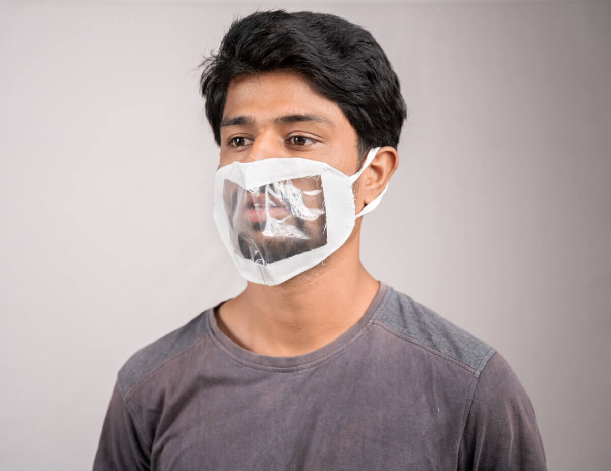 young man with transparent Medical face mask, to help hearing imperimeant or deaf people to understand lipreading during coronavirus or covid-19 outbreak.