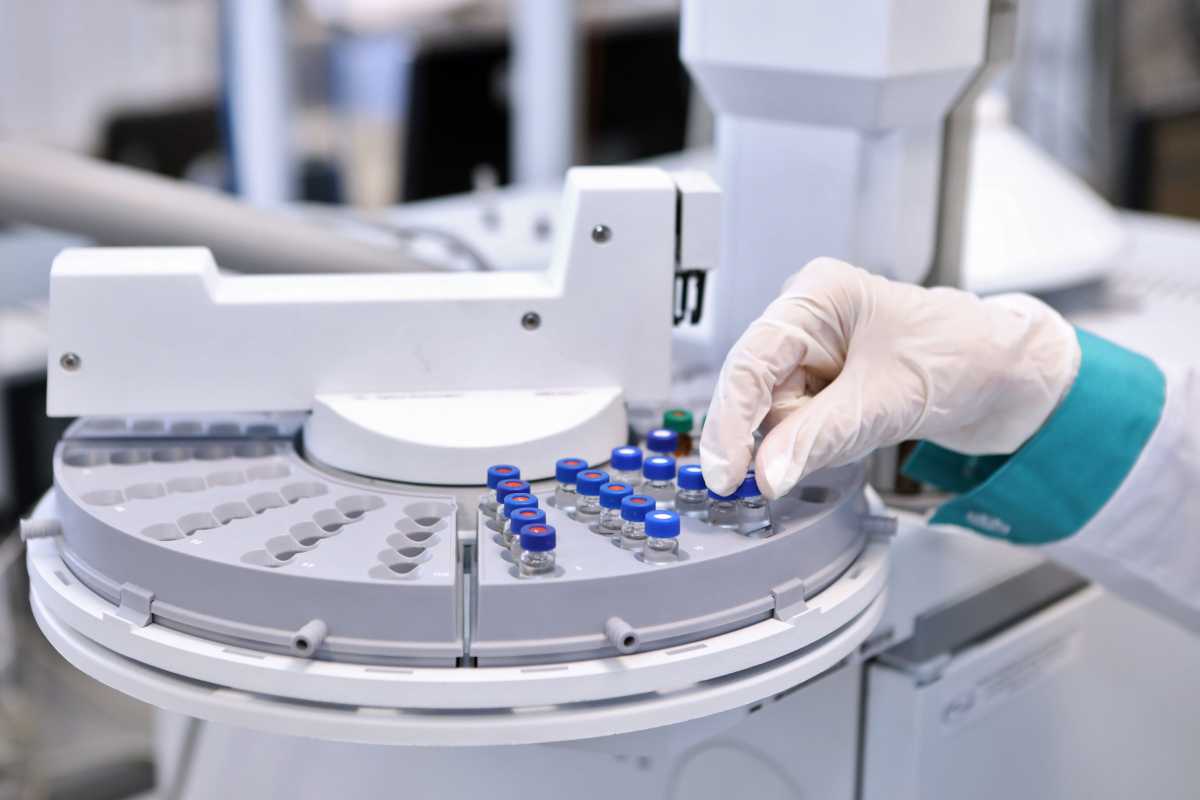 Quality Control Laboratory medicine. Chromatograph operation. A woman makes an analysis on a gas chromatograph. Development of a new vaccine against the covid-19 virus