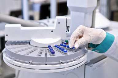 Quality Control Laboratory medicine. Chromatograph operation. A woman makes an analysis on a gas chromatograph. Development of a new vaccine against the covid-19 virus