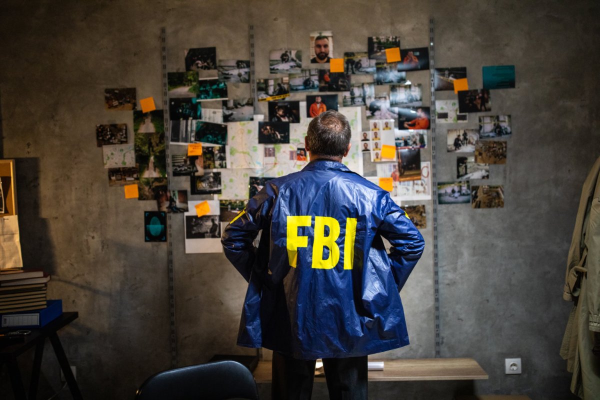 FBI detective looking at wall full of evidences and crime scene pictures
