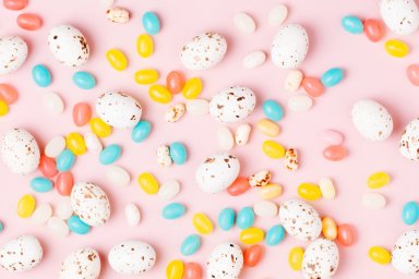 Easter candy chocolate eggs and Jellybean on pink background