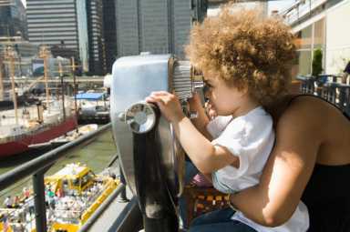 Mixed race boy looking through telescope