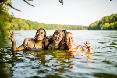 Portrait of three young women together in lake