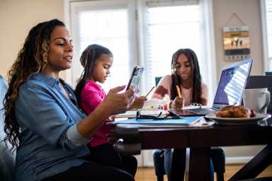 Mother working from home while daughters homeschool