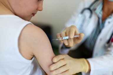 Boy getting a flu or coronavirus vaccine in the clinic