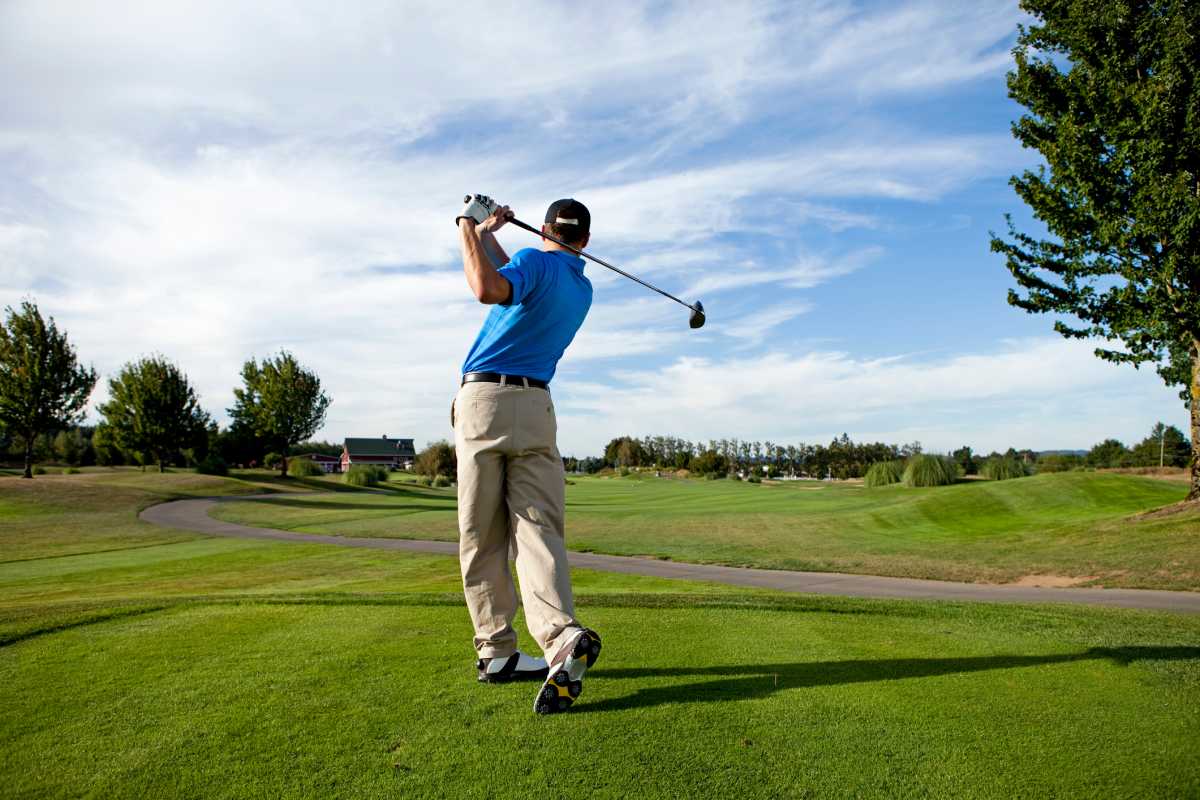 Man hitting a ball on the golf course.