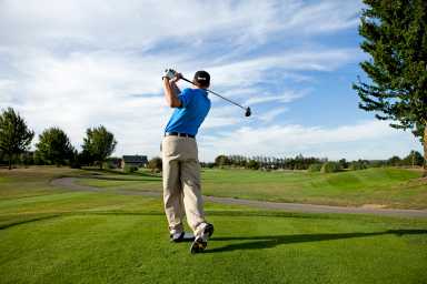 Man hitting a ball on the golf course.