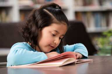 Hispanic student reading in library