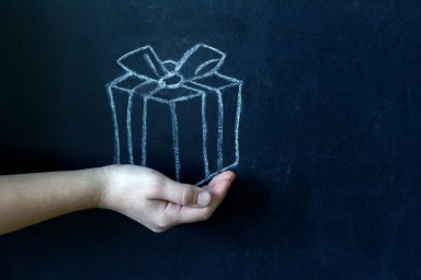 Present and child’s hand abstract background